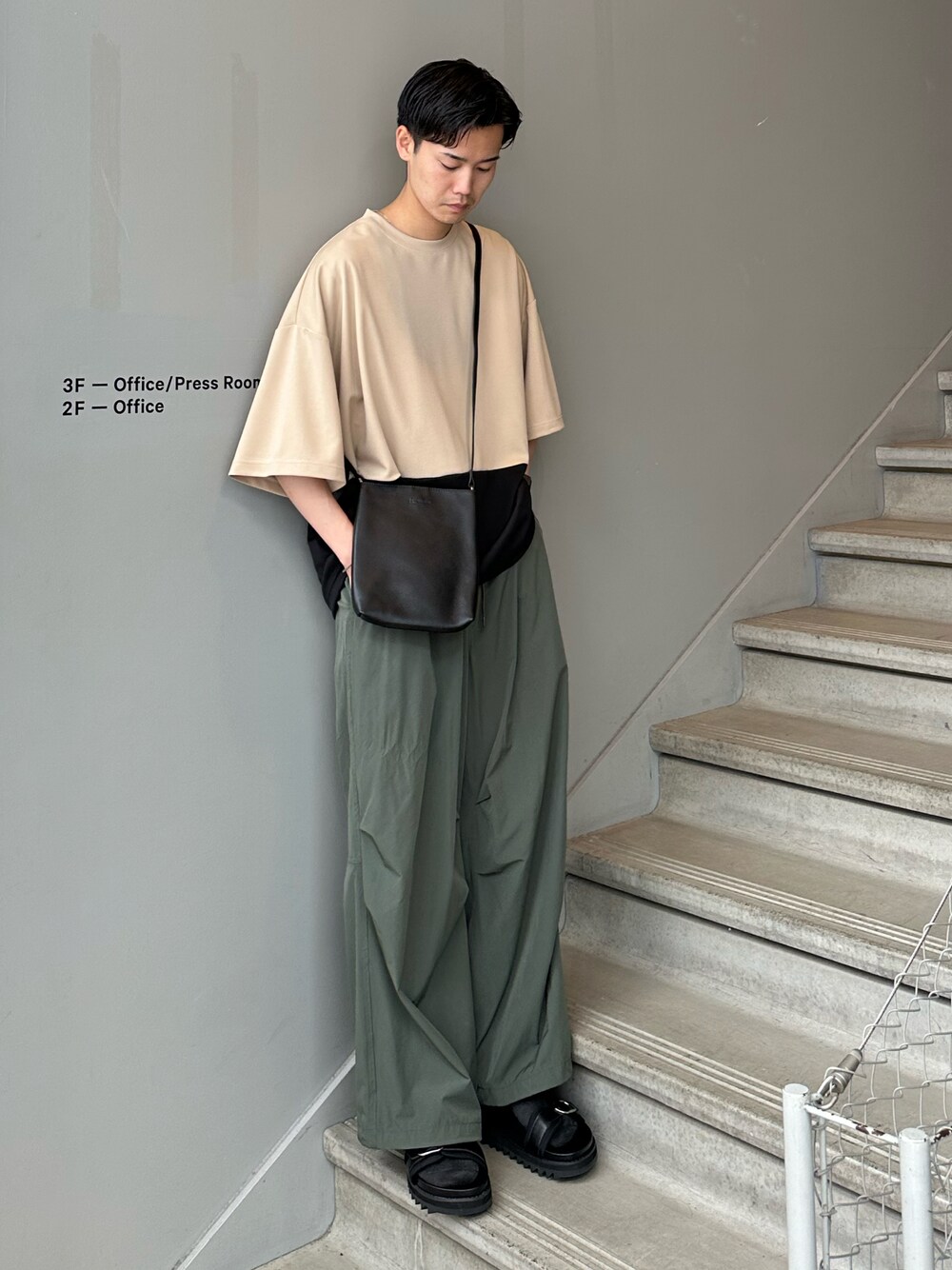 ベージュ系のTシャツ/カットソー、ブラック系のショルダーバッグ、グリーン系のその他パンツを着用したメンズの夏コーディネートの1枚目の写真
