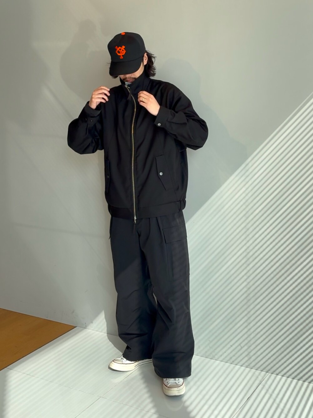 ブラック系のカーゴパンツ、ブラック系のブルゾンを着用したメンズの冬コーディネートの1枚目の写真