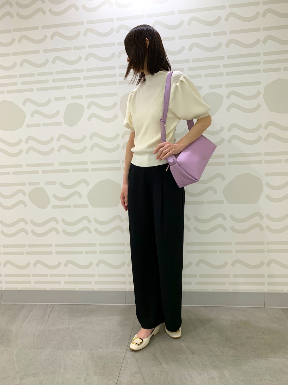 ベージュ系のパンプス、ピンク系のショルダーバッグを着用したレディースの春コーディネートの1枚目の写真