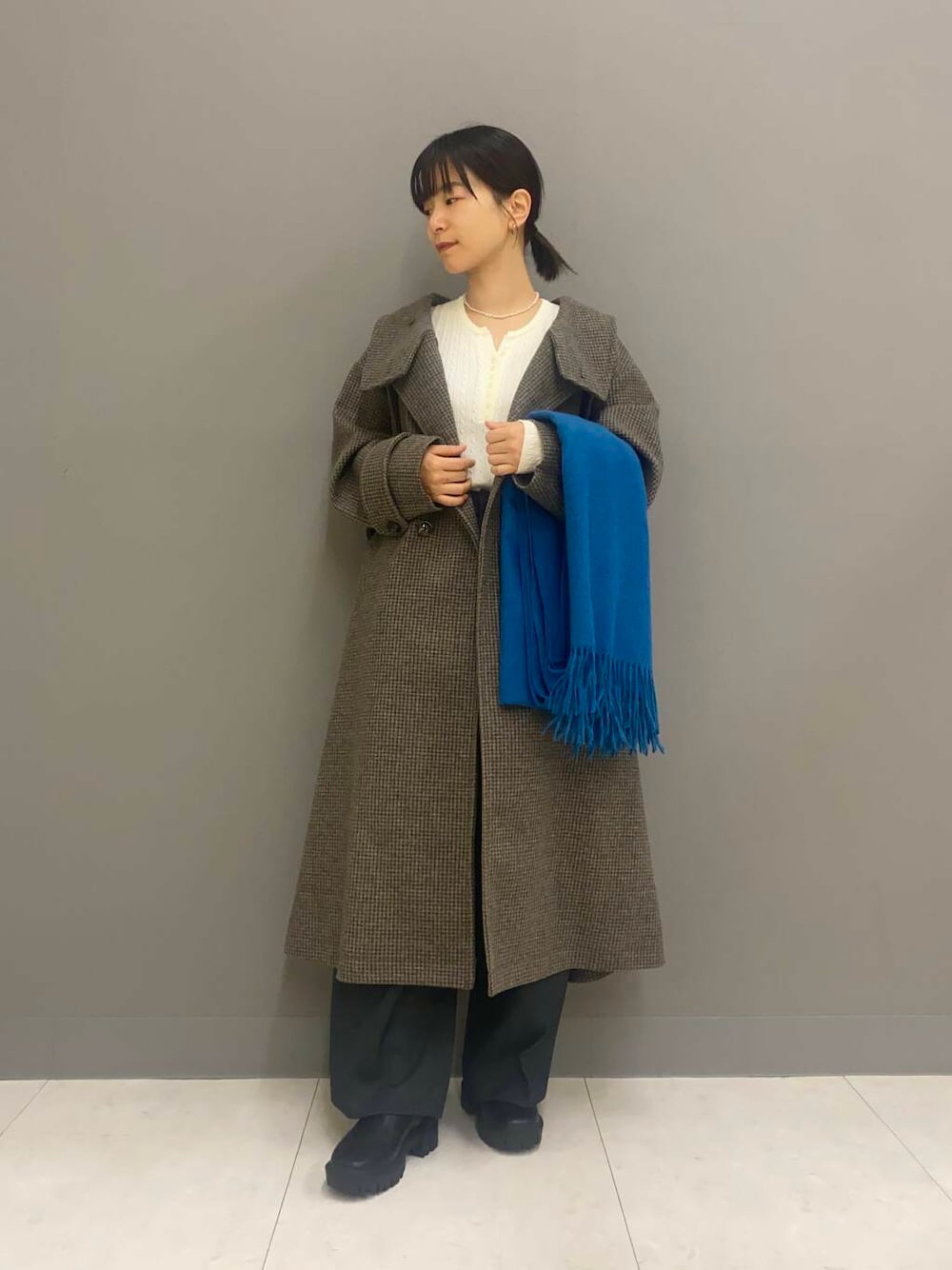 ブラック系のブーツ、グレー系のその他パンツ、ホワイト系のニット/セーターを着用したレディースの冬コーディネートの1枚目の写真