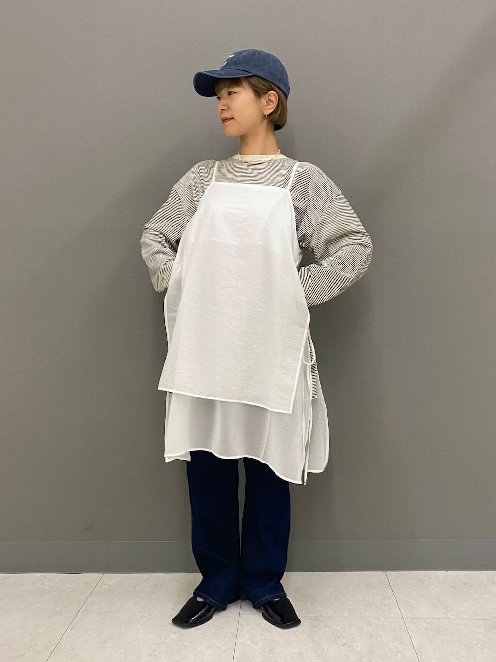 ブルー系のデニムパンツ、ブラック系のバレエシューズ、ホワイト系のワンピースを着用したレディースの夏コーディネートの1枚目の写真