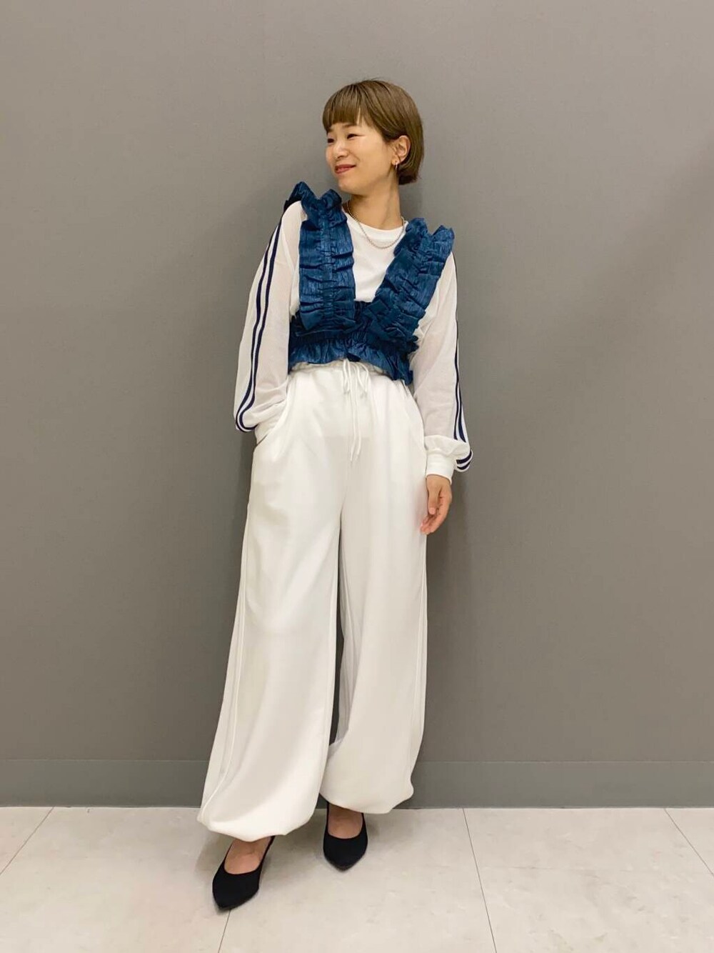 ブラック系のパンプス、ホワイト系のスウェットパンツ、ホワイト系のTシャツ/カットソーを着用したレディースの夏コーディネートの1枚目の写真