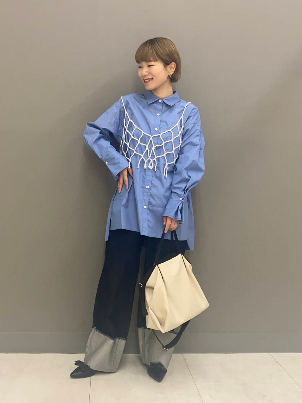 ホワイト系のショルダーバッグ、ブラック系のパンプス、ブルー系のTシャツ/カットソーを着用したレディースの秋コーディネートの1枚目の写真