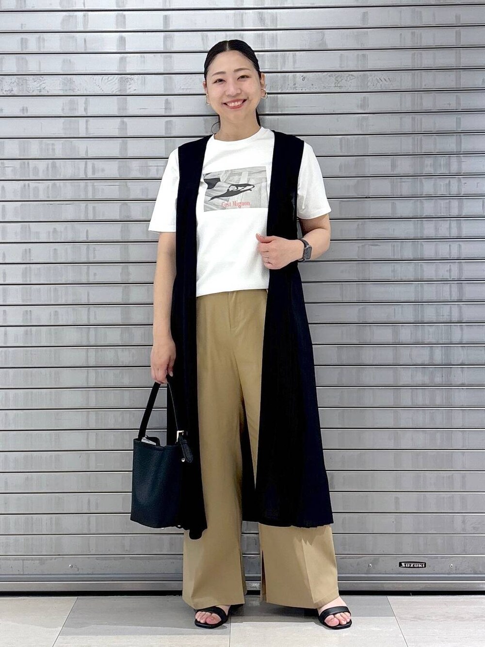 ブラック系のハンドバッグ、ホワイト系のTシャツ/カットソー、ブラウン系のその他パンツを着用したレディースの春コーディネートの1枚目の写真