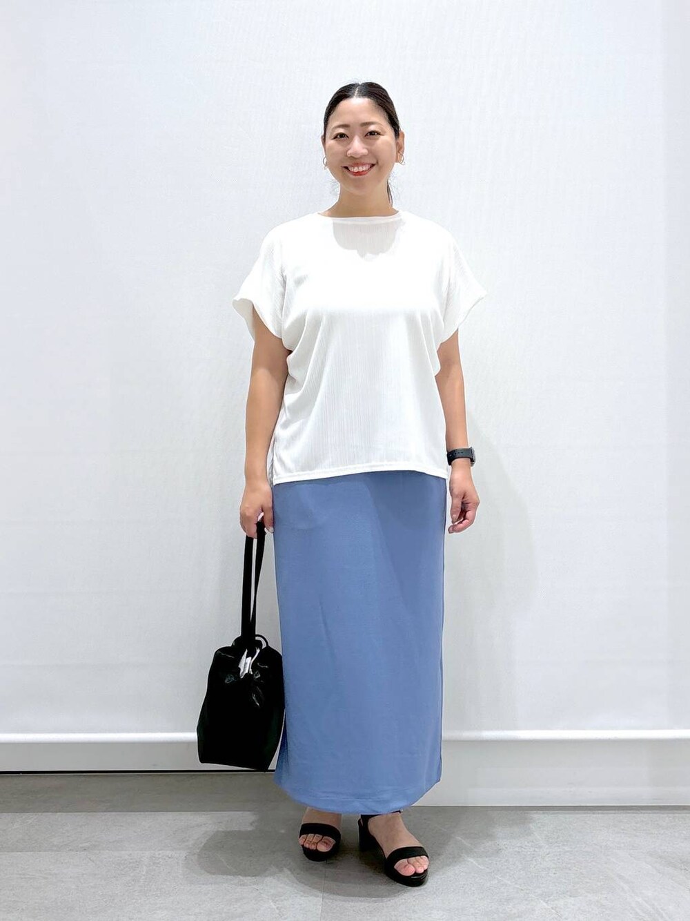 ホワイト系のTシャツ/カットソー、ブラック系のサンダル、ブルー系のスカートを着用したレディースの夏コーディネートの1枚目の写真