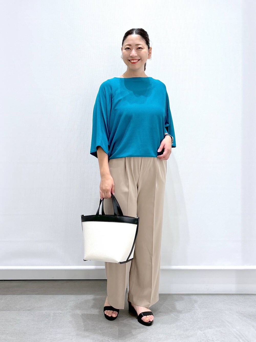 ベージュ系のその他パンツ、ブラック系のサンダル、ブラック系のトートバッグを着用したレディースの夏コーディネートの1枚目の写真