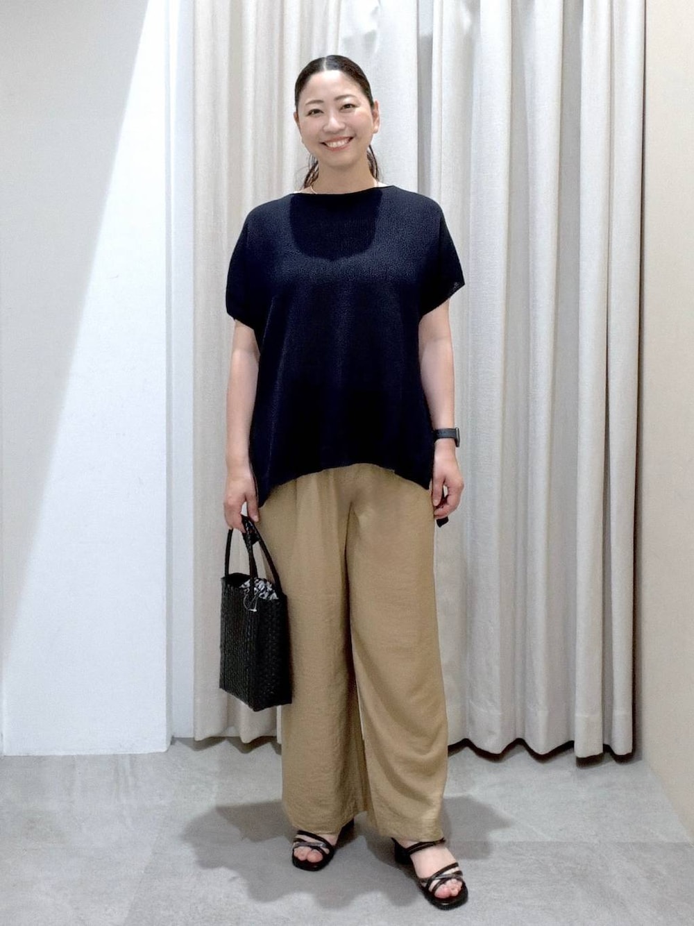 ブラック系のサンダル、ベージュ系のその他パンツ、ブラック系のかごバッグを着用したレディースの夏コーディネートの1枚目の写真