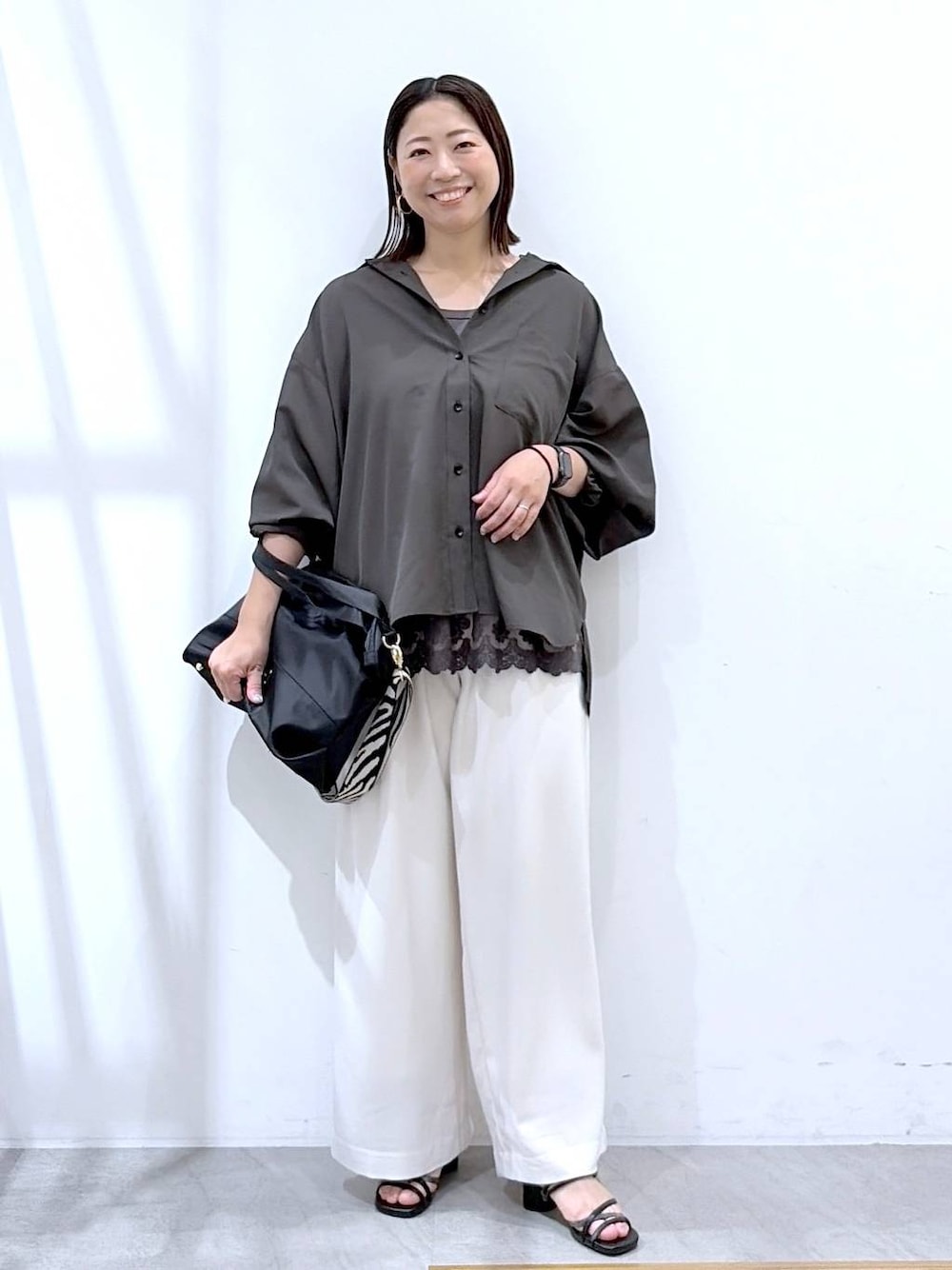 ブラック系のトートバッグ、グレー系のタンクトップ、ブラック系のサンダルを着用したレディースの夏コーディネートの1枚目の写真