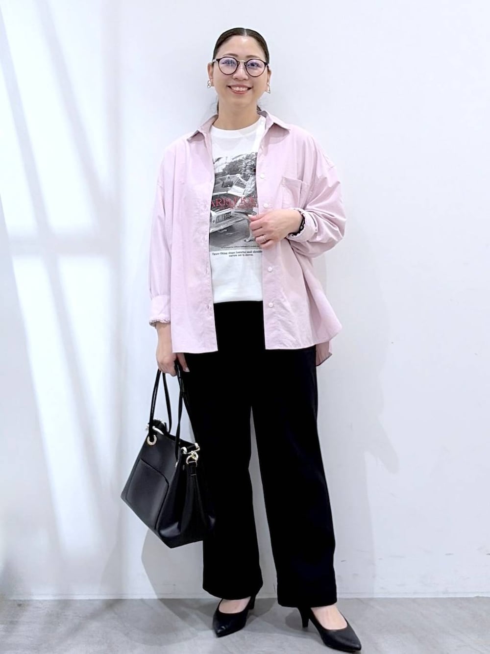 ブラック系のその他パンツ、ブラック系のトートバッグ、ピンク系のシャツ/ブラウスを着用したレディースの春コーディネートの1枚目の写真