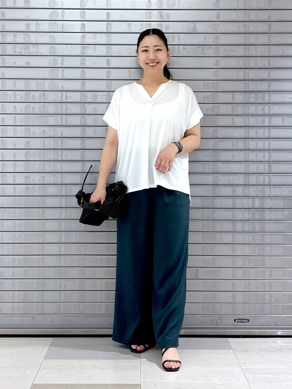 ホワイト系のTシャツ/カットソー、ブラック系のサンダルを着用したレディースの夏コーディネートの1枚目の写真