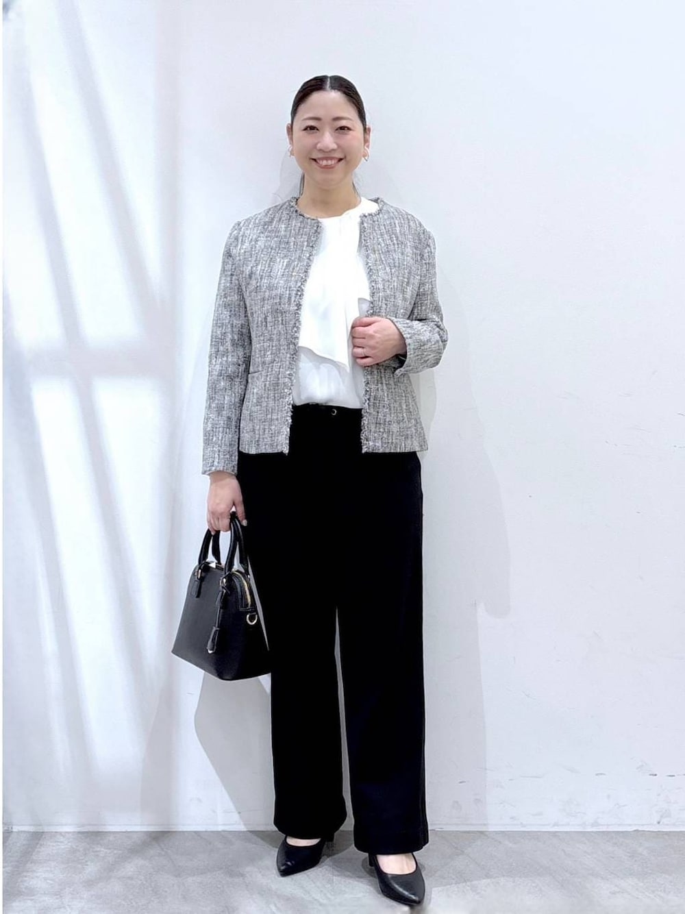 ブラック系のハンドバッグ、ブラック系のその他パンツ、ブラック系のノーカラージャケットを着用したレディースの冬コーディネートの1枚目の写真