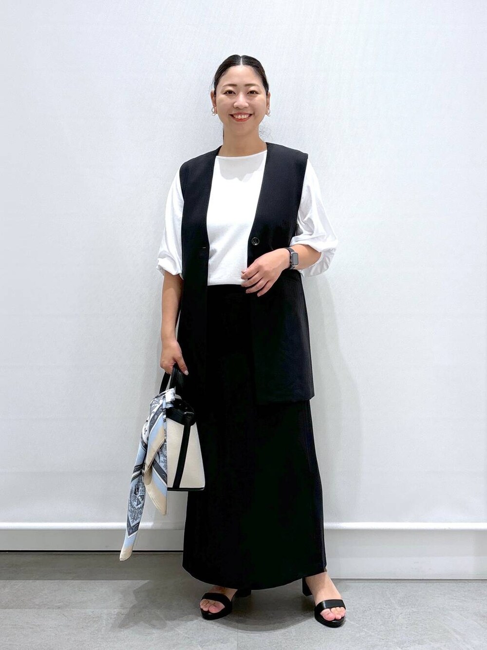 ブラック系のトートバッグ、ブラック系のサンダル、ブラック系のスカートを着用したレディースの秋コーディネートの1枚目の写真