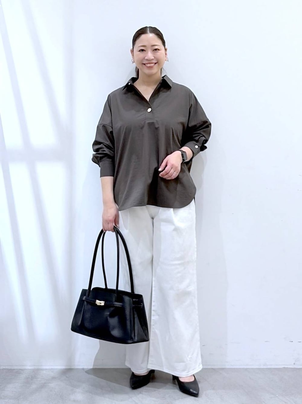 ホワイト系のデニムパンツ、ブラック系のハンドバッグ、ブラウン系のシャツ/ブラウスを着用したレディースの春コーディネートの1枚目の写真