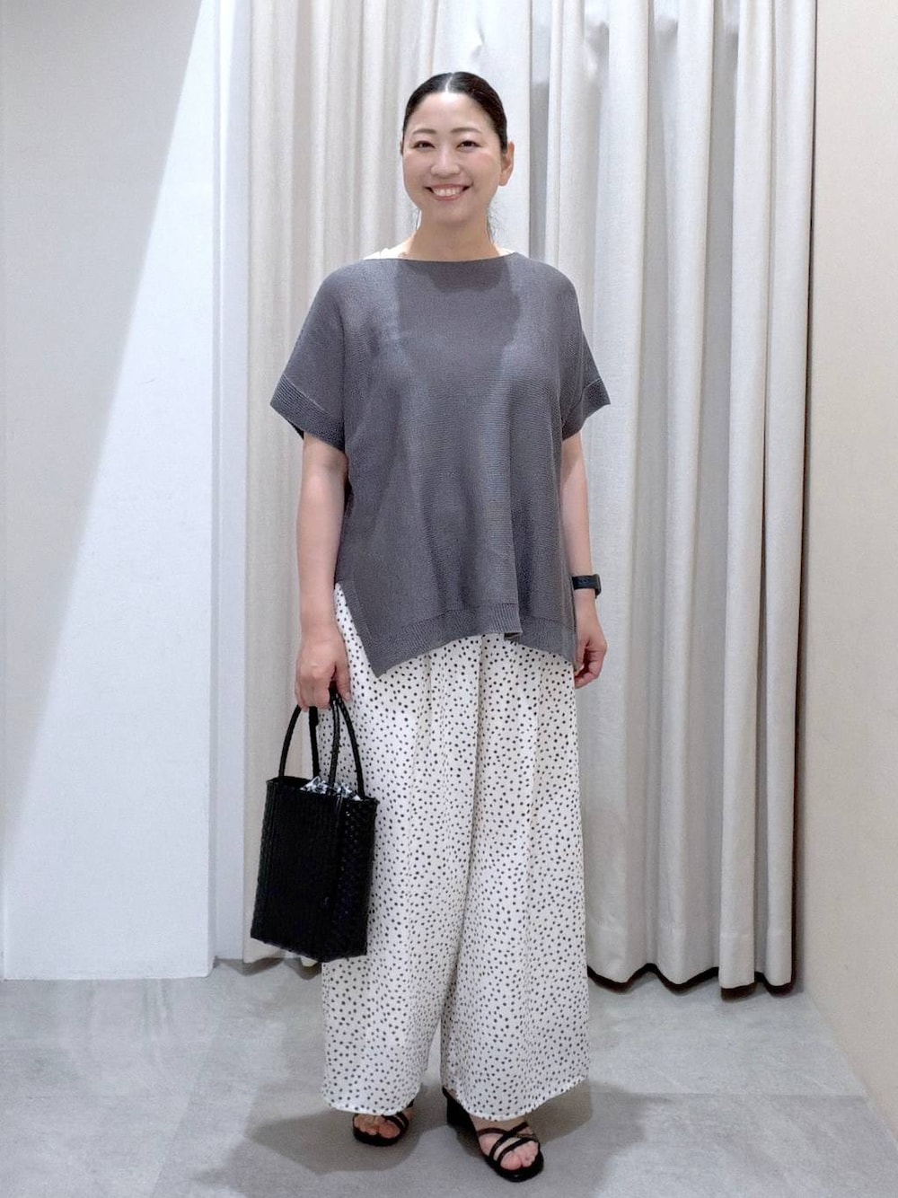 ブラック系のサンダル、ホワイト系のその他パンツ、ブラック系のかごバッグを着用したレディースの夏コーディネートの1枚目の写真