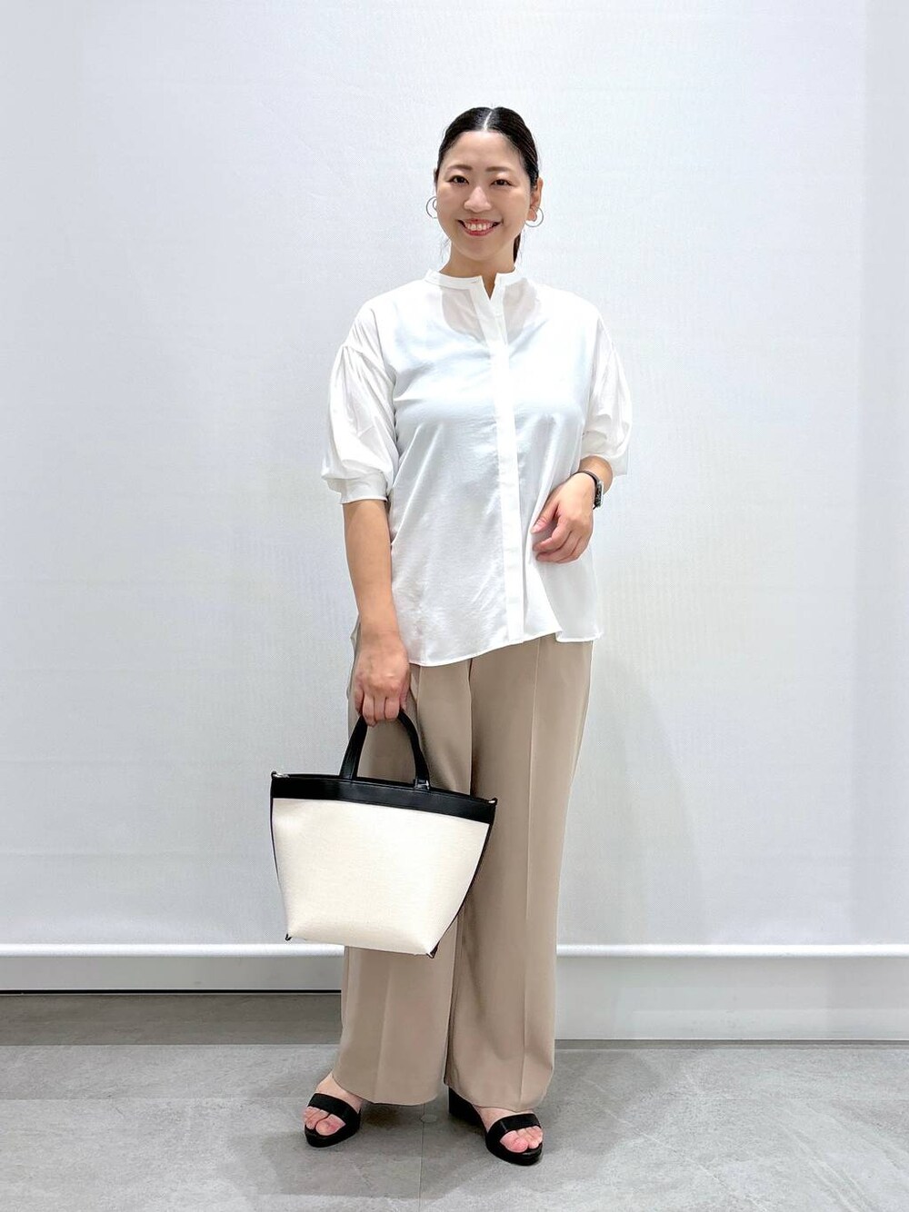 ベージュ系のその他パンツ、ブラック系のサンダル、ホワイト系のシャツ/ブラウスを着用したレディースの夏コーディネートの1枚目の写真