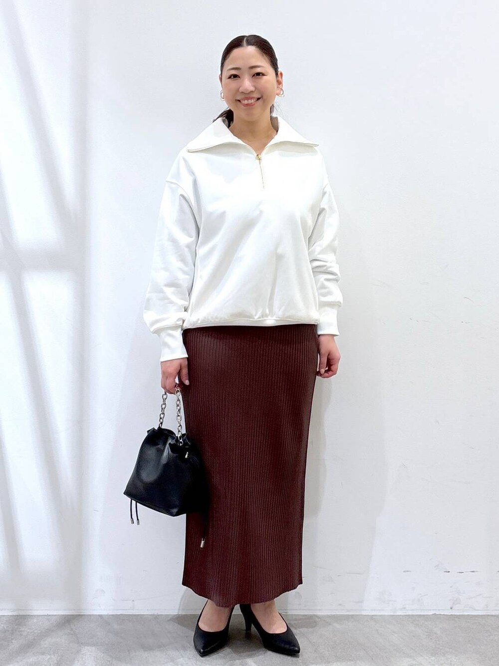 ブラウン系のスカート、ホワイト系のTシャツ/カットソーを着用したレディースの春コーディネートの1枚目の写真