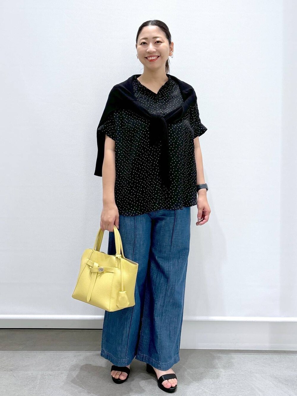 ブルー系のデニムパンツ、ブラック系のシャツ/ブラウス、ブラック系のサンダルを着用したレディースの夏コーディネートの1枚目の写真