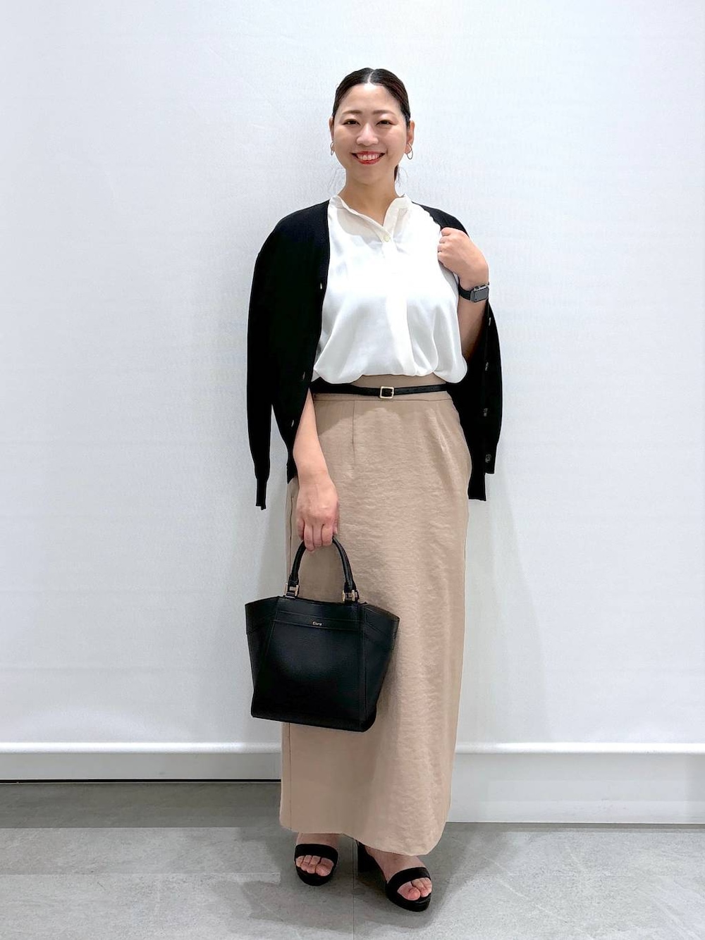 ブラック系のカーディガン/ボレロ、ホワイト系のシャツ/ブラウス、ブラック系のハンドバッグを着用したレディースの夏コーディネートの1枚目の写真