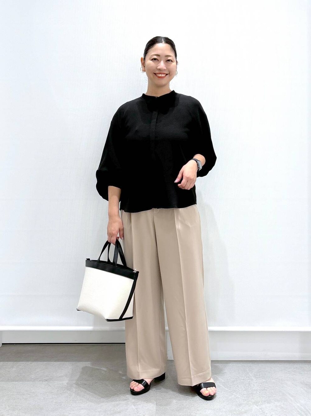 ベージュ系のその他パンツ、ブラック系のサンダル、ブラック系のシャツ/ブラウスを着用したレディースの夏コーディネートの1枚目の写真