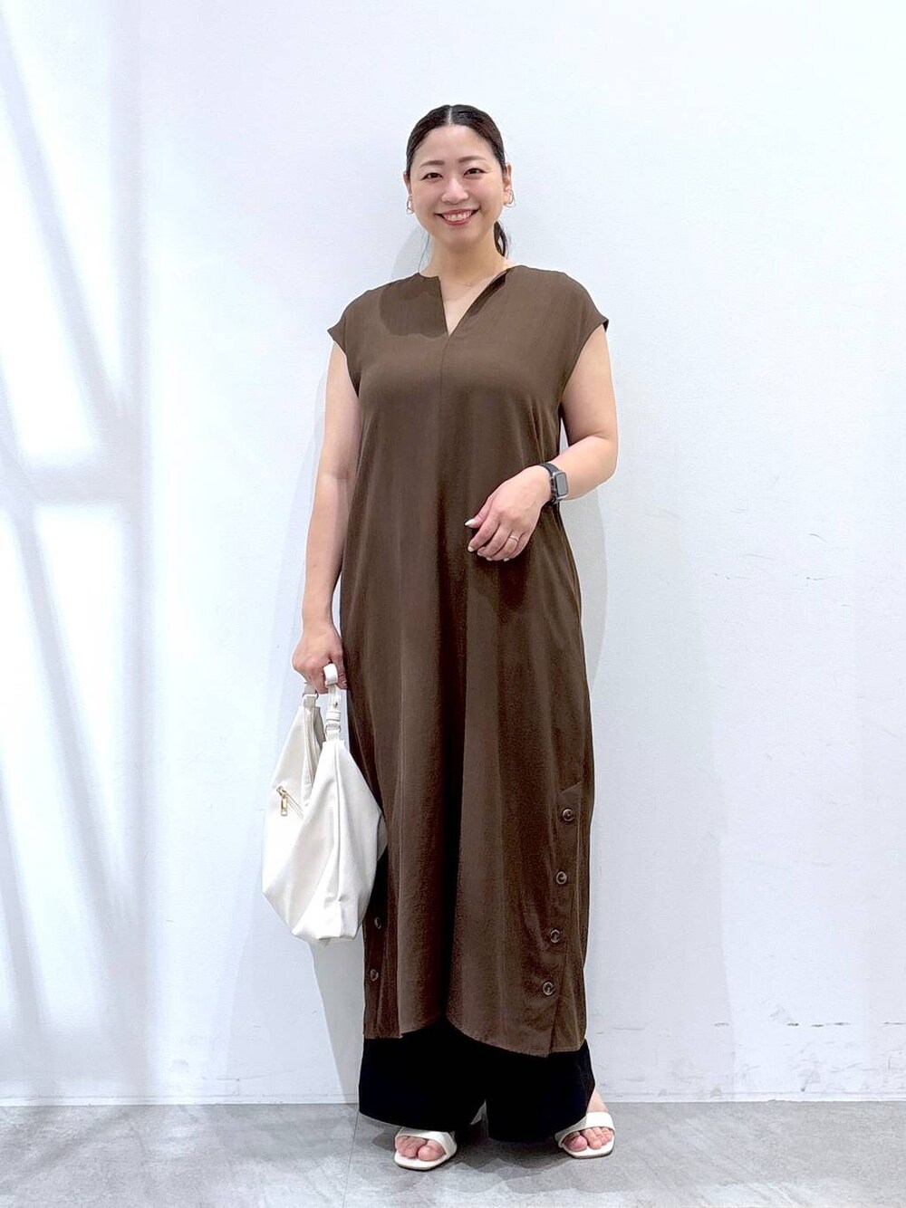 ブラック系のその他パンツ、ホワイト系のハンドバッグ、ブラウン系のワンピースを着用したレディースの夏コーディネートの1枚目の写真