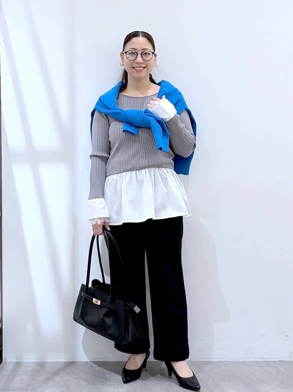 ブラック系のその他パンツ、ブラック系のハンドバッグ、ブルー系のカーディガン/ボレロを着用したレディースの春コーディネートの1枚目の写真