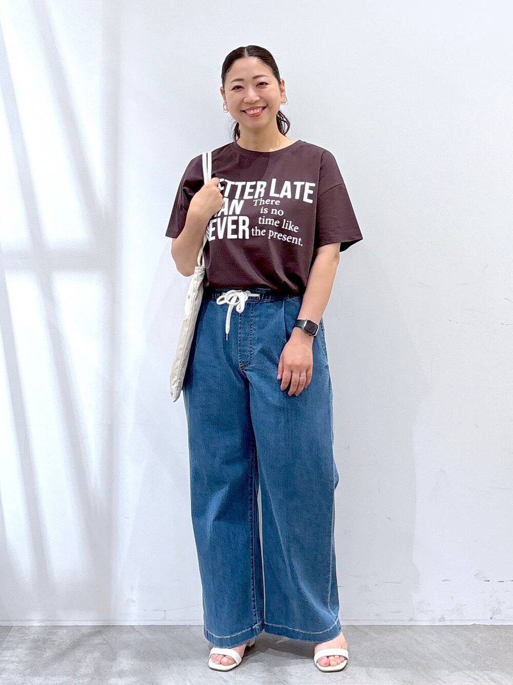 ホワイト系のトートバッグ、ブルー系のデニムパンツ、ブラウン系のTシャツ/カットソーを着用したレディースの夏コーディネートの1枚目の写真