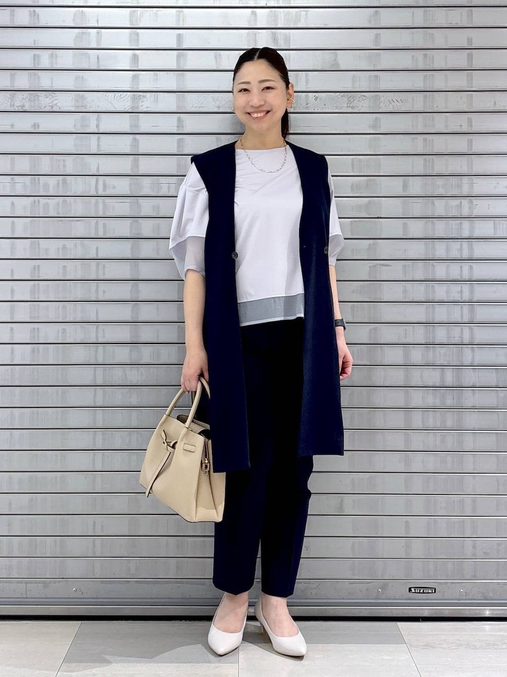 ホワイト系のパンプス、ベージュ系のハンドバッグ、ブルー系のその他パンツを着用したレディースの春コーディネートの1枚目の写真