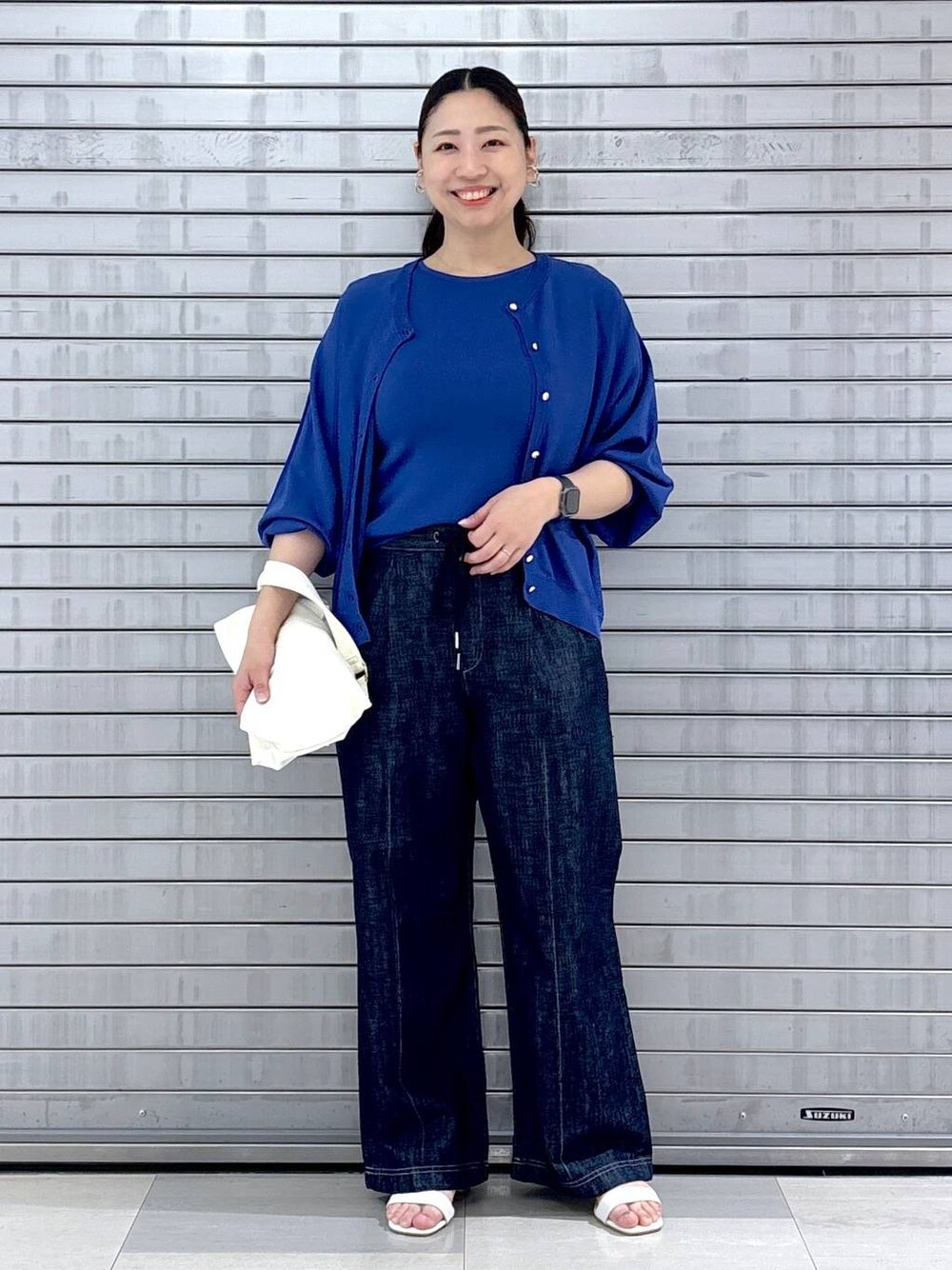 ブルー系のカーディガン/ボレロ、ブルー系のニット/セーター、ブルー系のデニムパンツを着用したレディースの春コーディネートの1枚目の写真