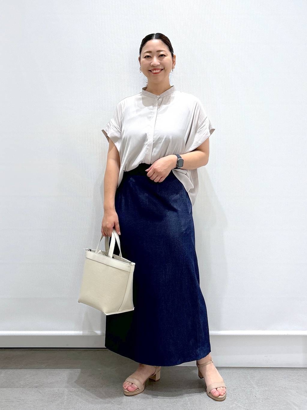 ベージュ系のシャツ/ブラウス、ベージュ系のサンダル、ブルー系のデニムスカートを着用したレディースの夏コーディネートの1枚目の写真