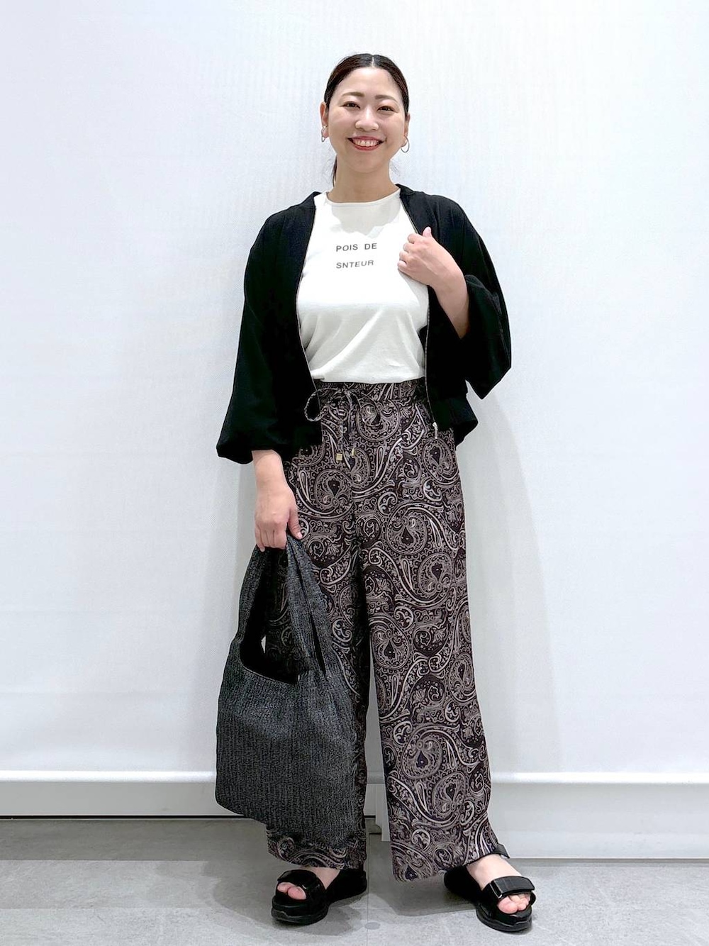 ホワイト系のTシャツ/カットソー、ブラック系のサンダル、ブラック系のブルゾンを着用したレディースの春コーディネートの1枚目の写真