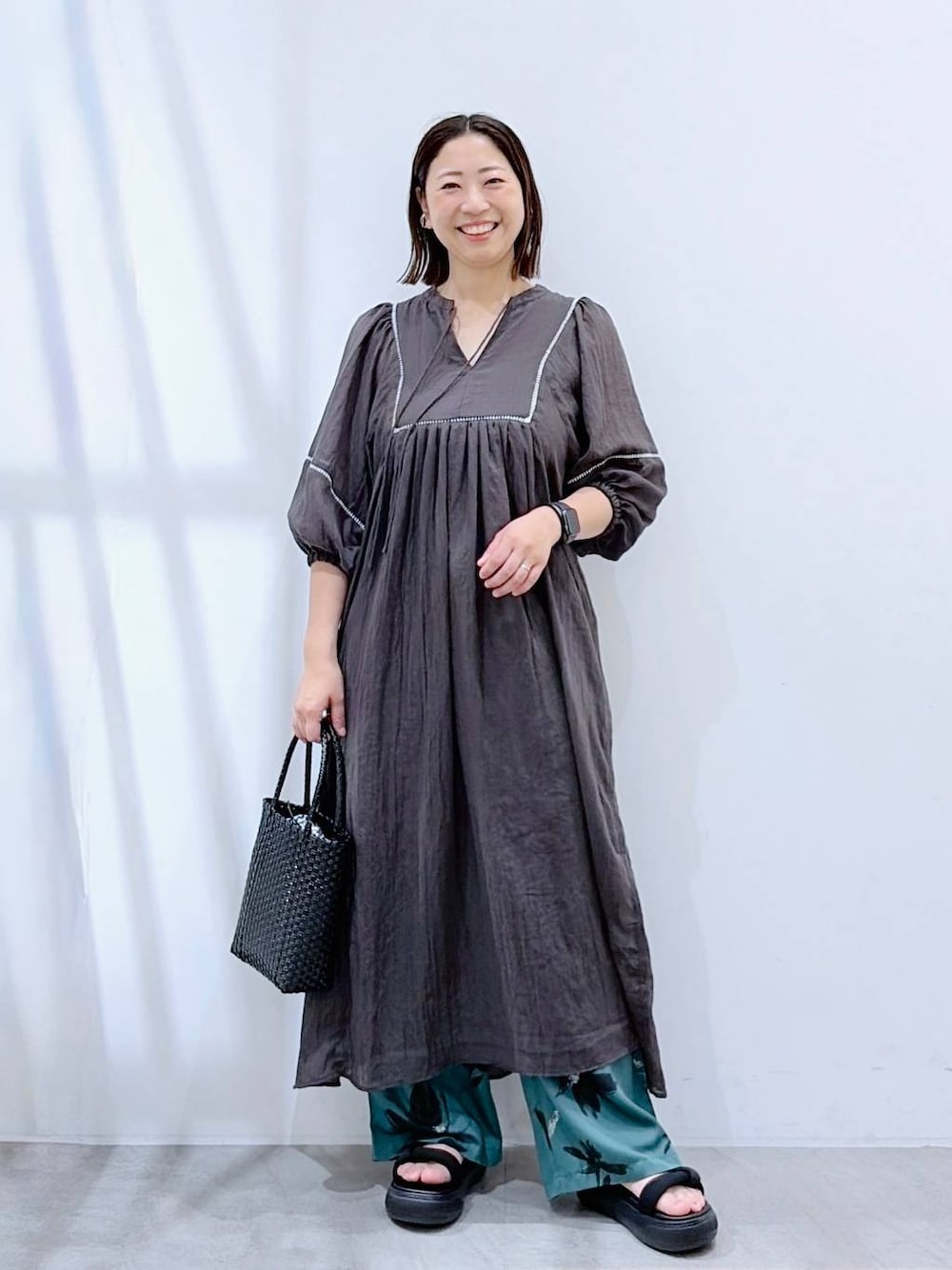 グリーン系のその他パンツ、ブラック系のかごバッグ、グレー系のワンピースを着用したレディースの夏コーディネートの1枚目の写真
