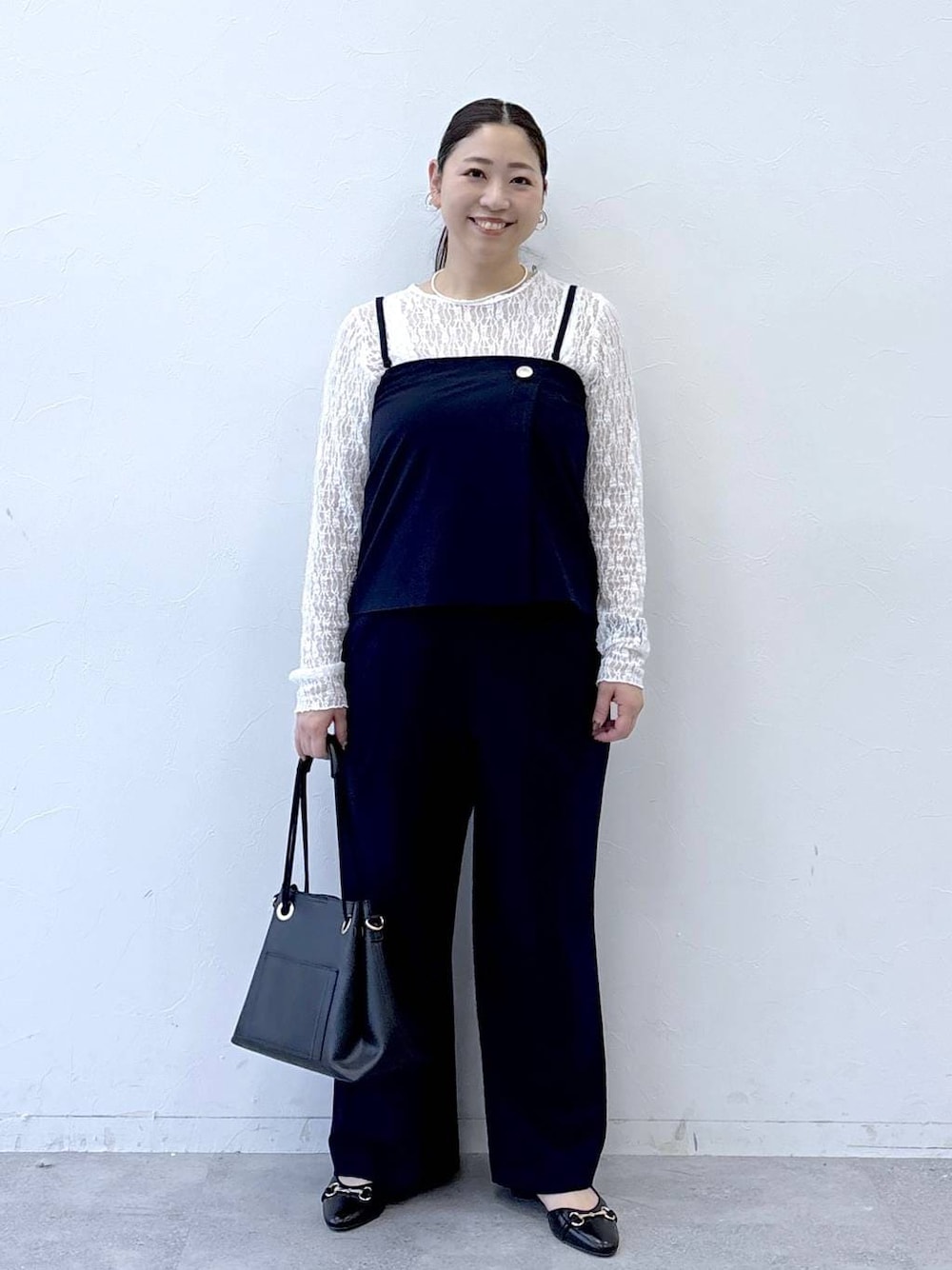 ブラック系のパンプス、ブラック系のトートバッグ、ブルー系のその他パンツを着用したレディースの冬コーディネートの1枚目の写真