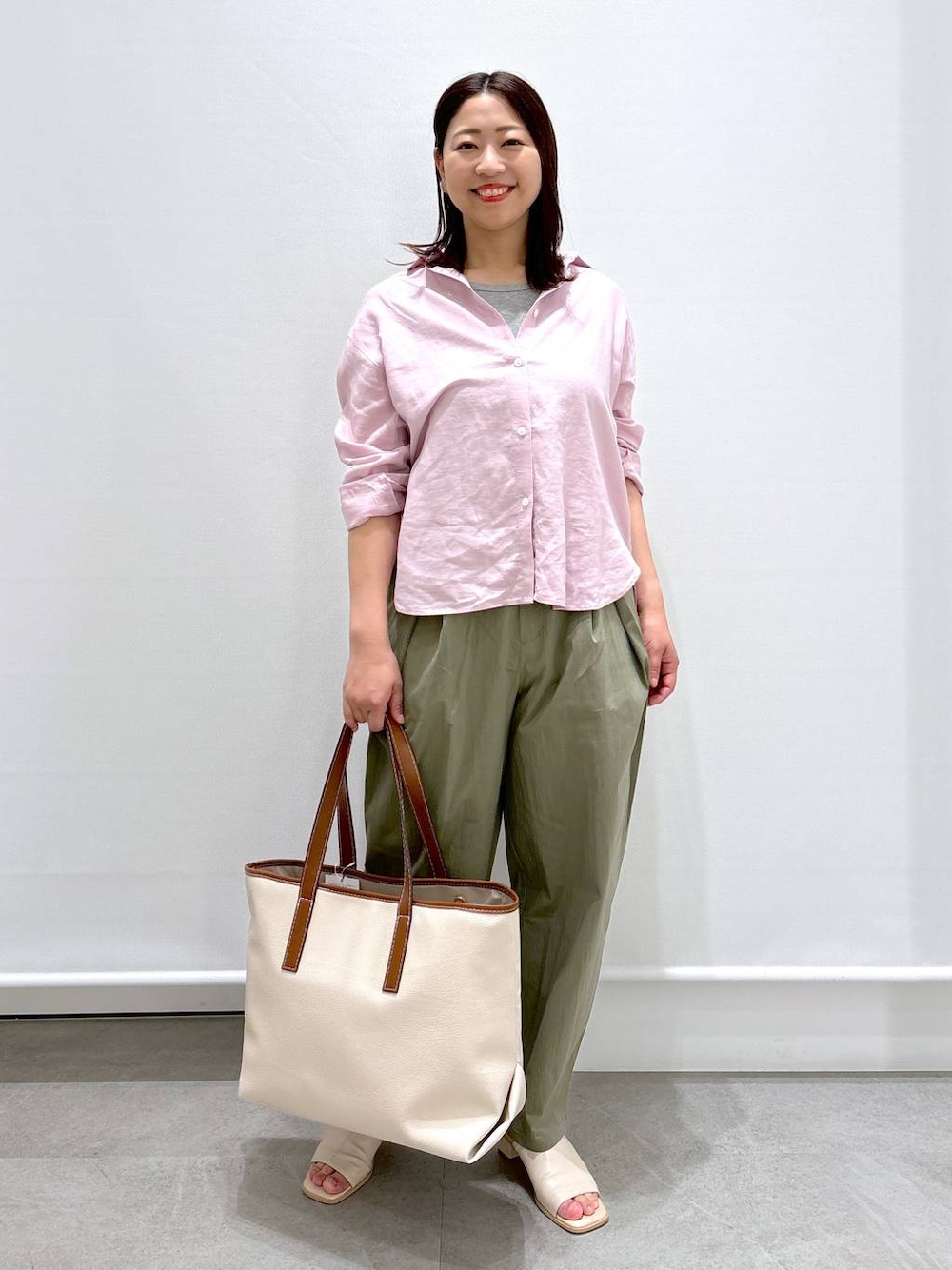 シルバー系のTシャツ/カットソー、グリーン系のその他パンツ、ホワイト系のトートバッグを着用したレディースの春コーディネートの1枚目の写真