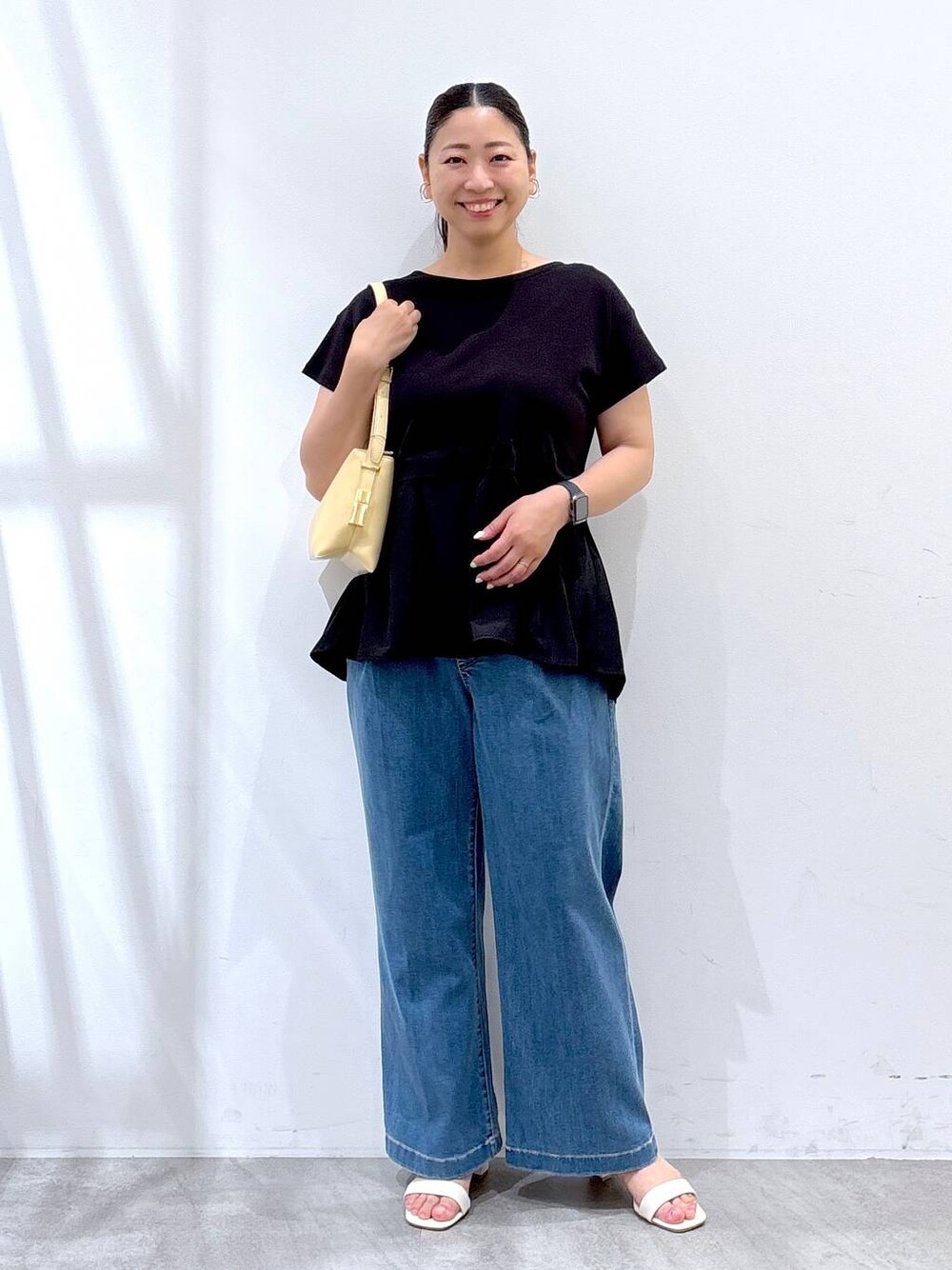 ブラック系のTシャツ/カットソー、ブルー系のデニムパンツを着用したレディースの夏コーディネートの1枚目の写真