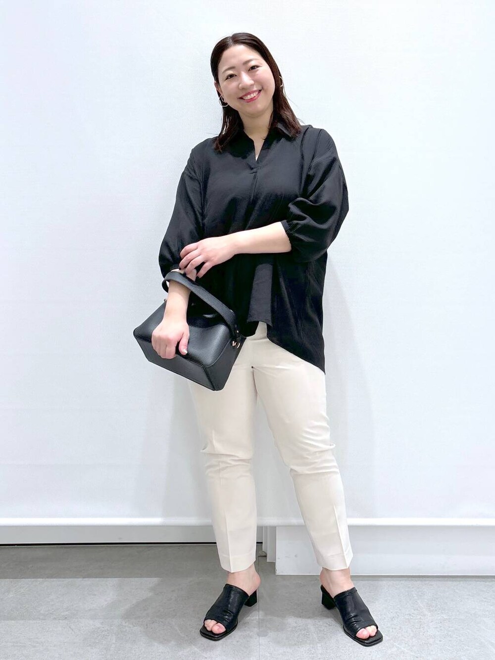 ホワイト系のその他パンツ、ブラック系のTシャツ/カットソー、ブラック系のハンドバッグを着用したレディースの春コーディネートの1枚目の写真