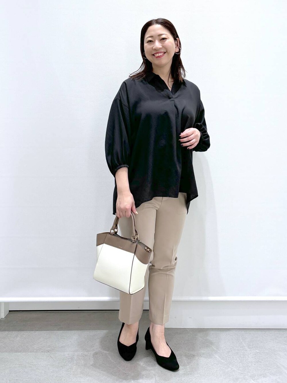 ベージュ系のその他パンツ、ホワイト系のハンドバッグ、ブラック系のパンプスを着用したレディースの春コーディネートの1枚目の写真