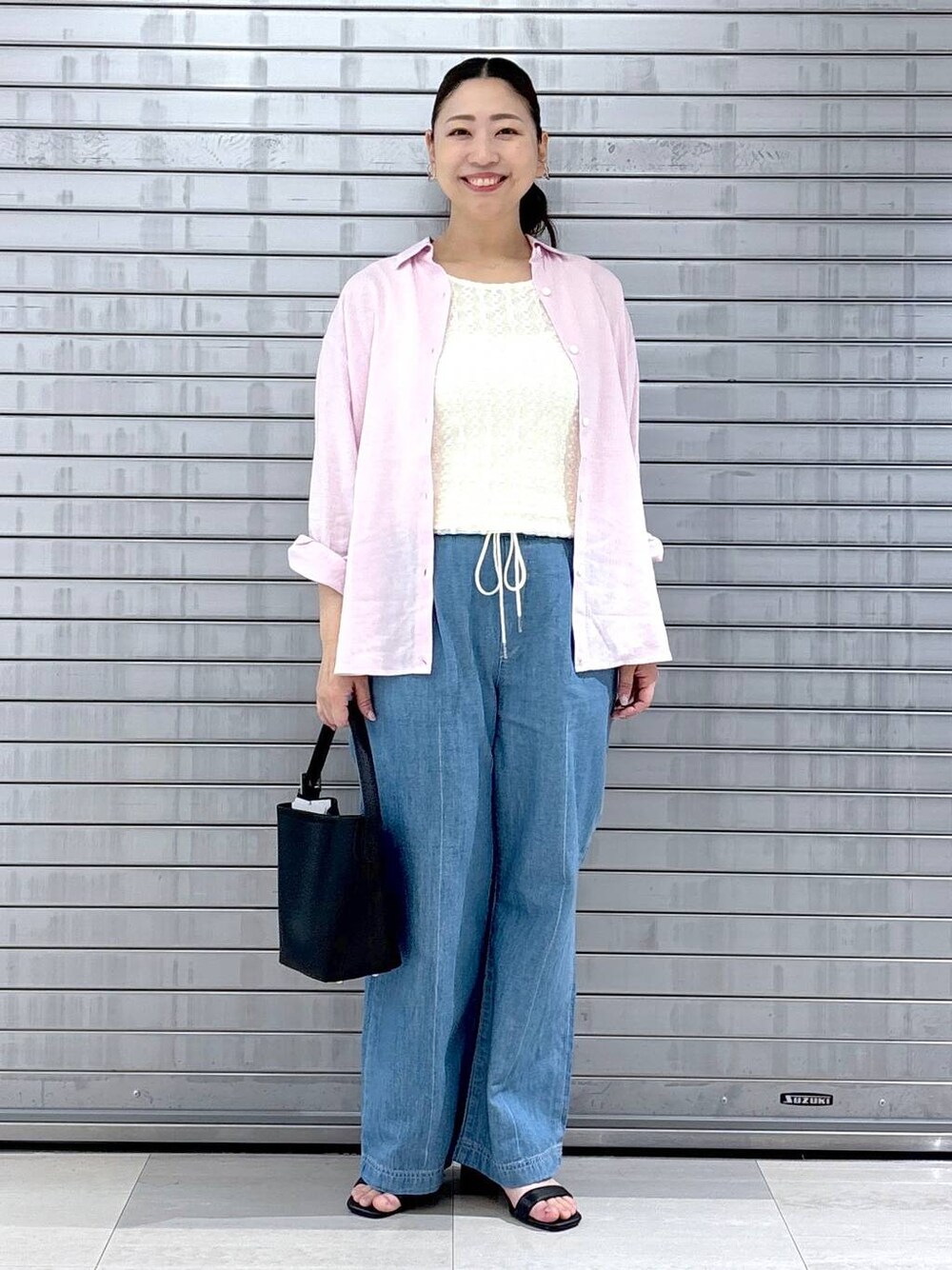 ブラック系のハンドバッグ、ピンク系のシャツ/ブラウス、ホワイト系のTシャツ/カットソーを着用したレディースの春コーディネートの1枚目の写真