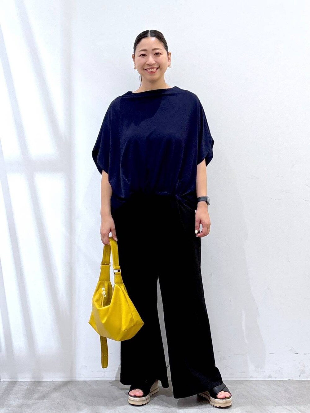 ブラック系のその他パンツ、イエロー系のハンドバッグ、ブルー系のTシャツ/カットソーを着用したレディースの夏コーディネートの1枚目の写真