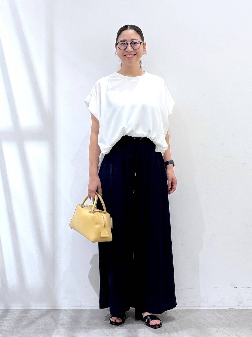 ブルー系のその他パンツ、ブラック系のサンダル、ホワイト系のTシャツ/カットソーを着用したレディースの夏コーディネートの1枚目の写真