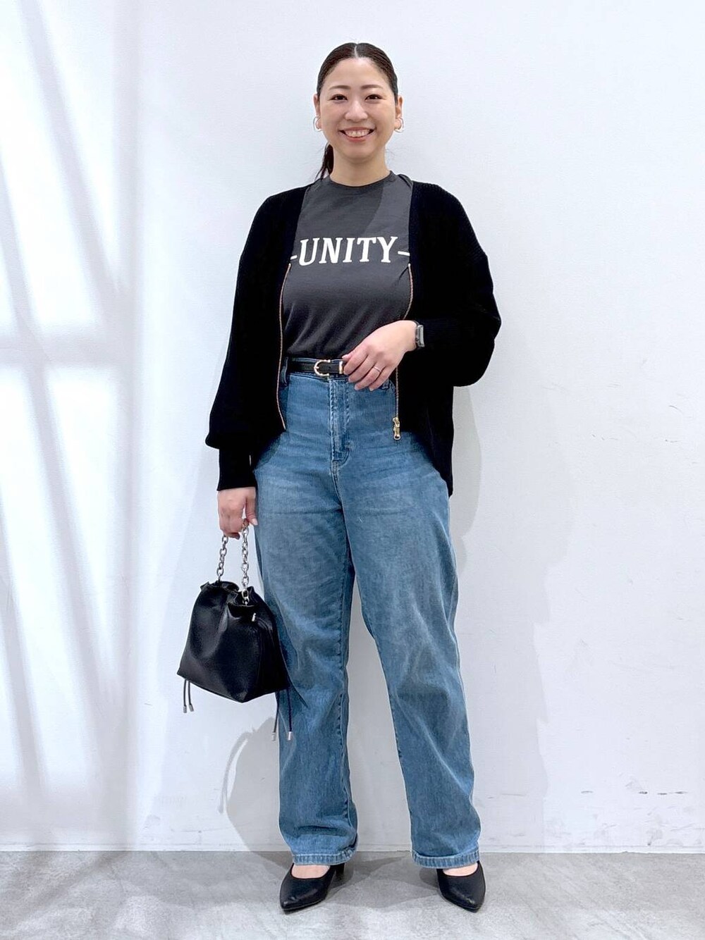 ブルー系のデニムパンツ、ブラック系のカーディガン/ボレロ、グレー系のTシャツ/カットソーを着用したレディースの春コーディネートの1枚目の写真