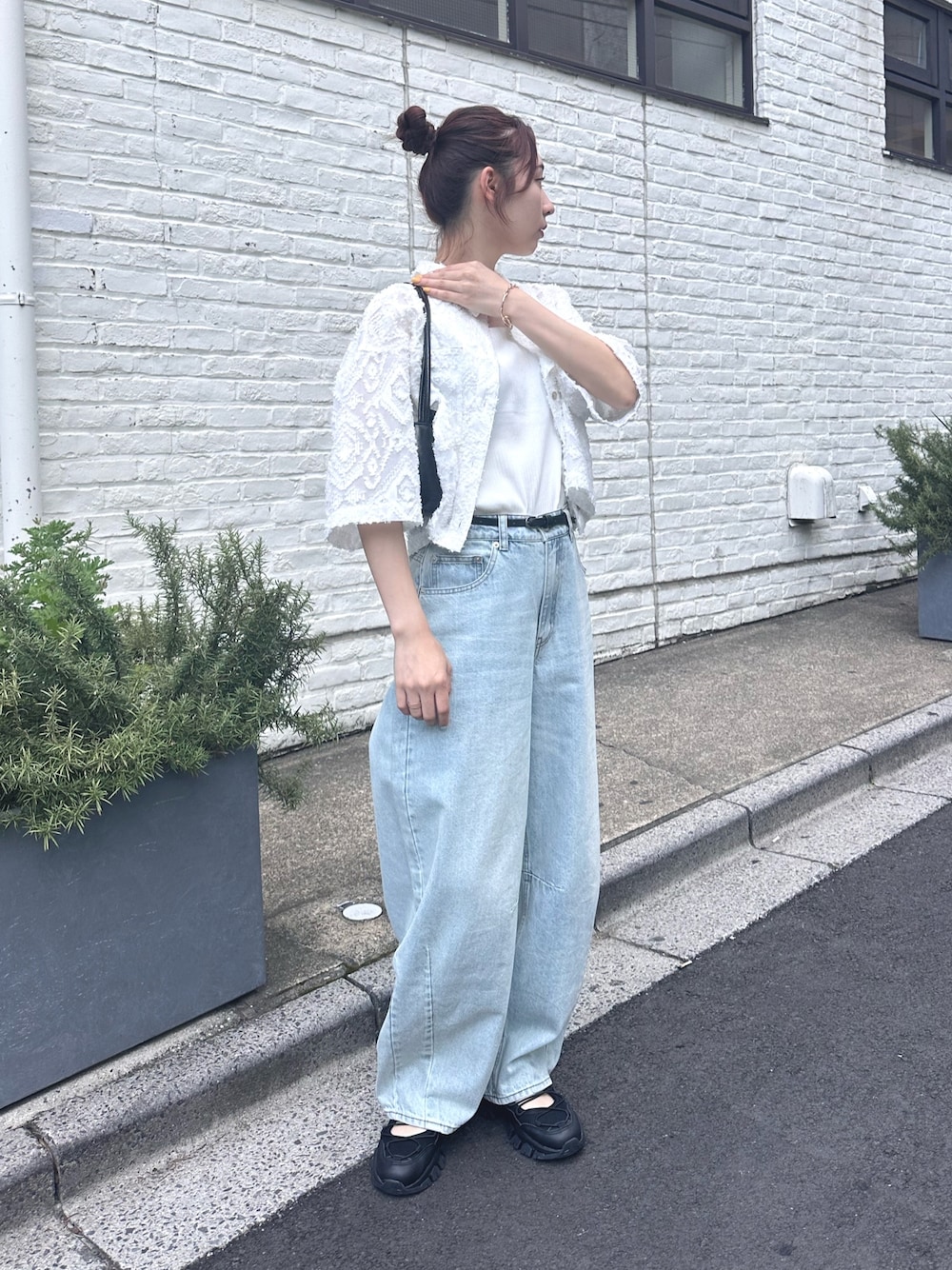ブルー系のデニムパンツ、ブラック系のサンダル、ホワイト系のシャツ/ブラウスを着用したレディースの夏コーディネートの1枚目の写真