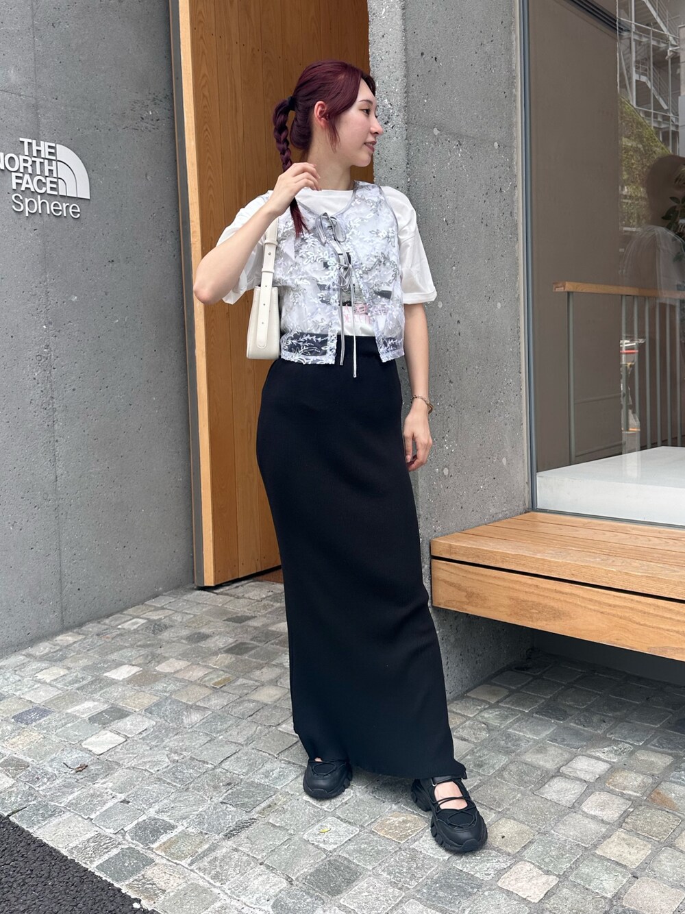 ブラック系のスカート、ブラック系のサンダル、シルバー系のベストを着用したレディースの夏コーディネートの1枚目の写真