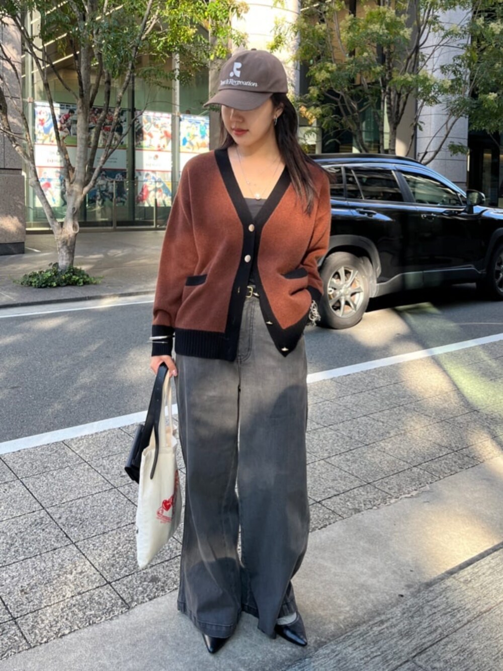 ブラウン系のカーディガン/ボレロ、ブルー系のデニムパンツを着用したレディースの秋コーディネートの1枚目の写真