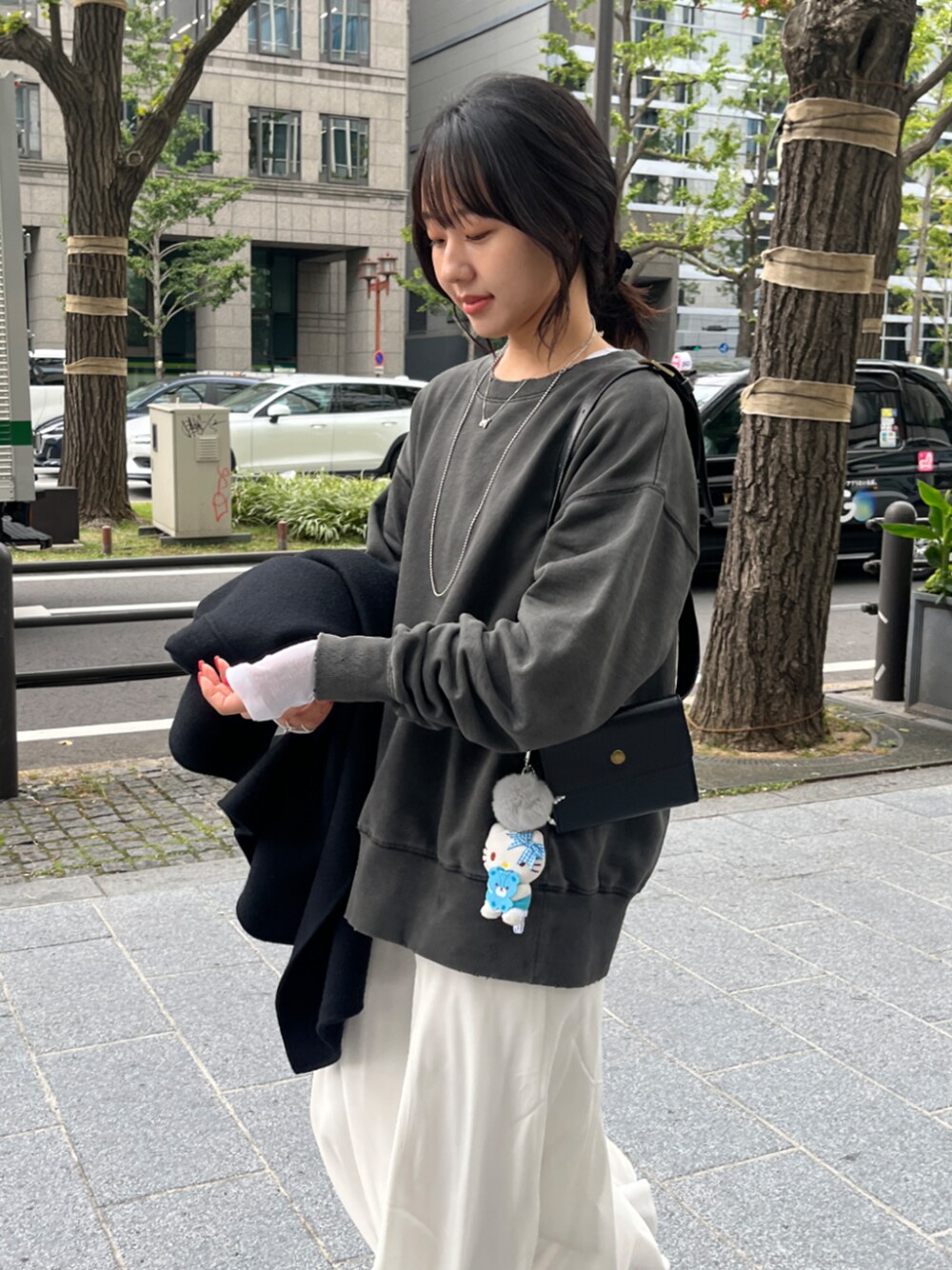 グレー系のTシャツ/カットソー、ホワイト系のスカート、ホワイト系のTシャツ/カットソーを着用したレディースの秋コーディネートの1枚目の写真
