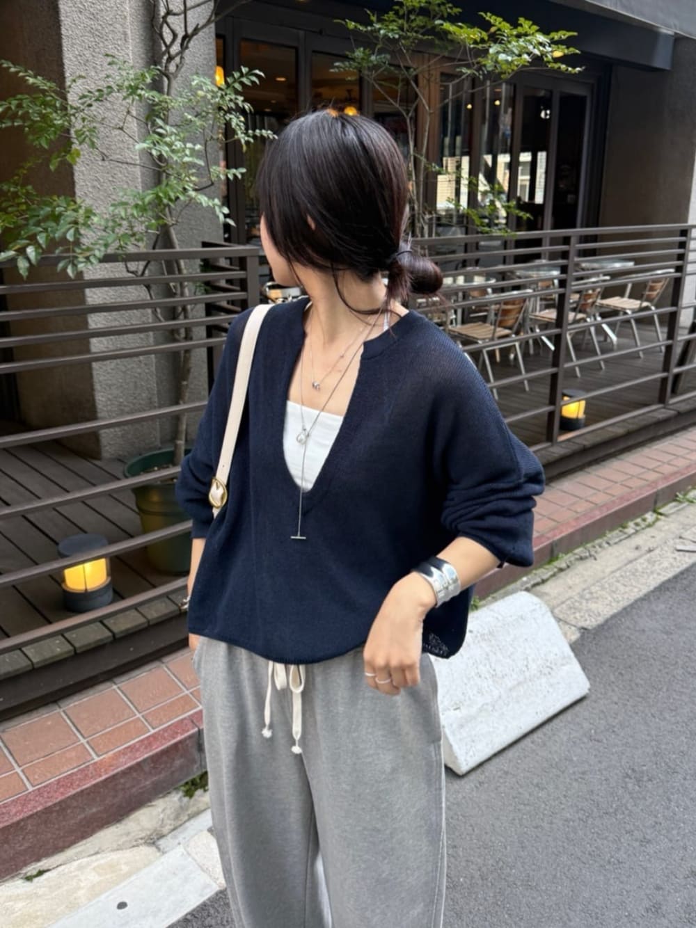 グレー系のその他パンツ、ホワイト系のキャミソール、ブルー系のニット/セーターを着用したレディースの春コーディネートの1枚目の写真