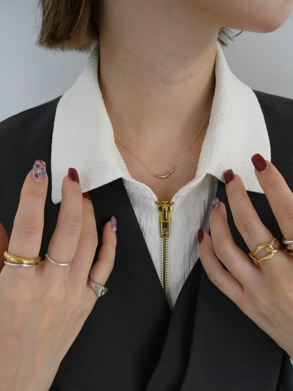 シルバー系のネックレス、ゴールド系のリング、シルバー系のリングを着用したレディースの秋コーディネートの1枚目の写真