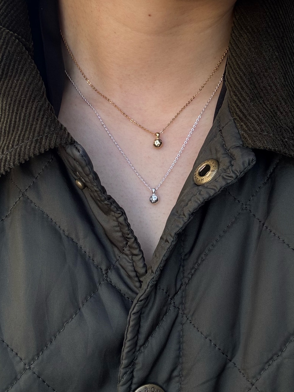 シルバー系のネックレス、ゴールド系のネックレスを着用したレディースの春コーディネートの1枚目の写真