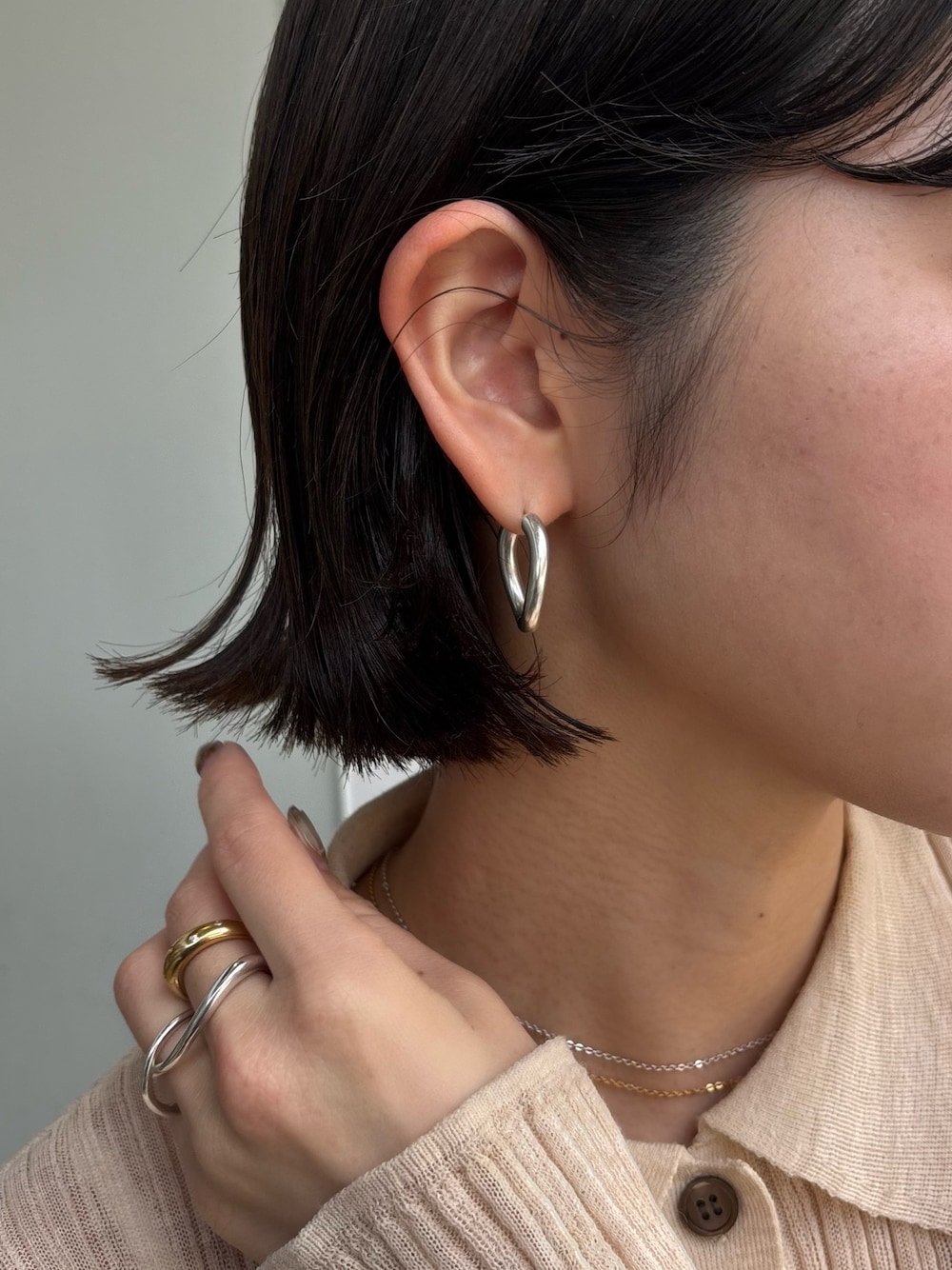 シルバー系のピアス(両耳用)、シルバー系のリング、ゴールド系のリングを着用したレディースの春コーディネートの1枚目の写真