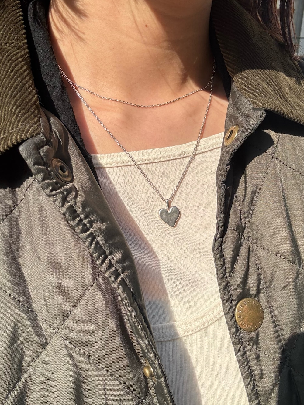 シルバー系のネックレス、シルバー系のネックレスを着用したレディースの冬コーディネートの1枚目の写真