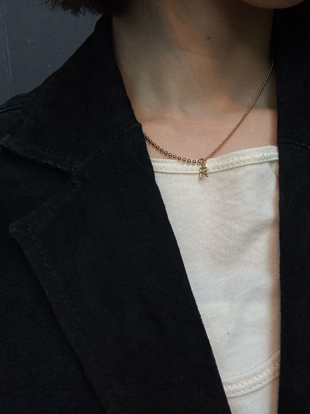 ゴールド系のチャーム、ゴールド系のネックレスを着用したレディースの冬コーディネートの1枚目の写真